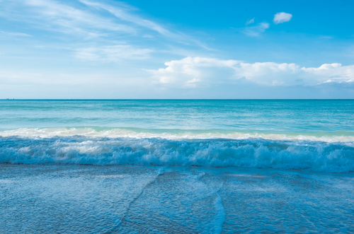 Free A tranquil seascape capturing blue ocean waves gently lapping against the shoreline on a sunny day. Stock Photo