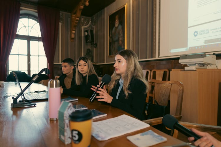 Women Sitting And Speaking On Conference