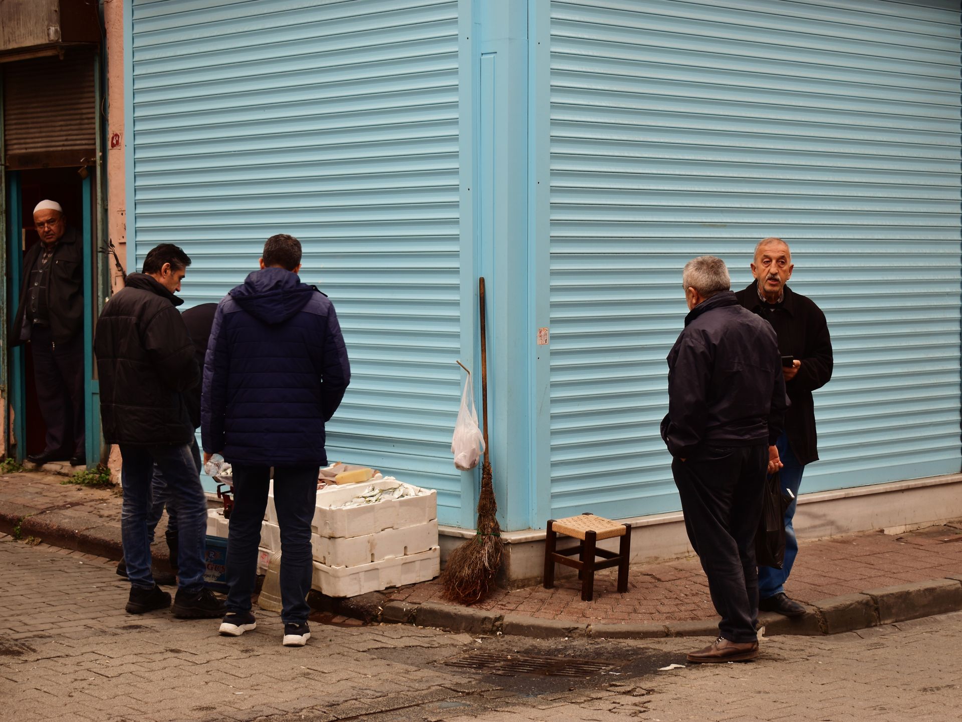 Street scene in Istanbul showing people interacting with a local vendor on a sidewalk.