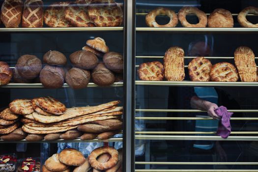 A diverse assortment of baked breads displayed in a bakery window in Istanbul, Turkey.