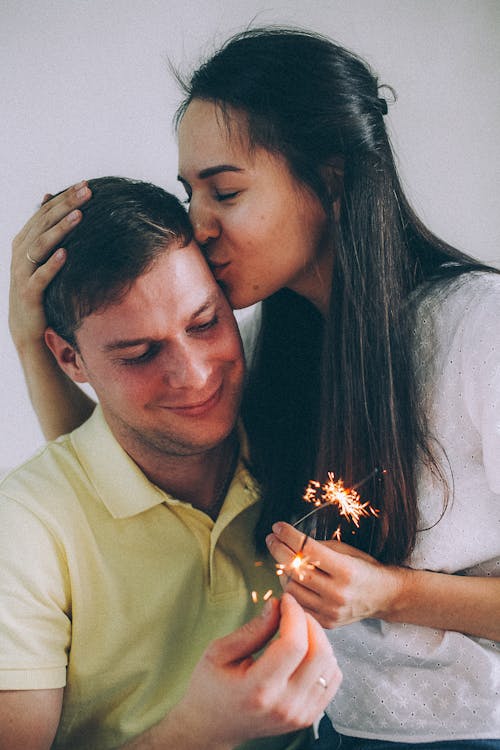 Couple Holding Sparklers and Smiling 