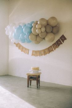 Charming indoor setup with balloons and cake for a simple birthday celebration.