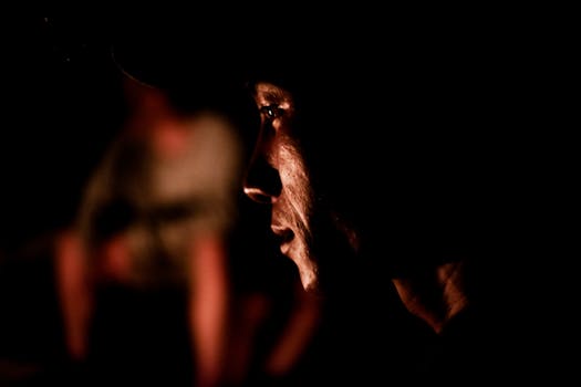 在黑暗、戏剧性的灯光下，一名男子的强烈侧面轮廓捕捉到了情感和情绪