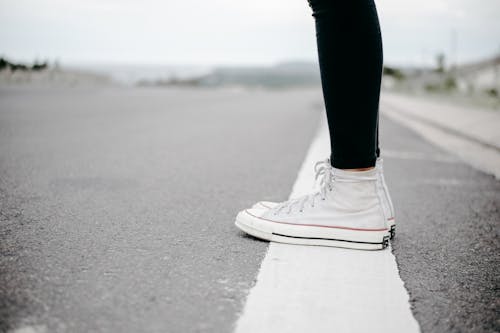 Free Person Wearing White High-top Lace-up Sneakers Standing on White Line Stock Photo