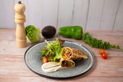 Free Delicious healthy wrap with fresh vegetables and sauce, perfect for a nutritious meal. Stock Photo