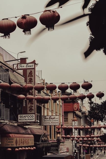 Vibrant Chinatown street scene with hanging lanterns and restaurant signs.