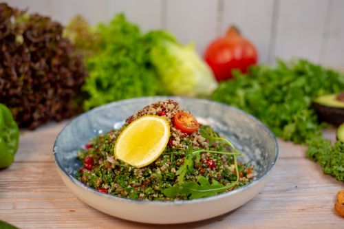 Free Vibrant quinoa salad with fresh herbs and lemon slice, garnished with cherry tomato. Stock Photo