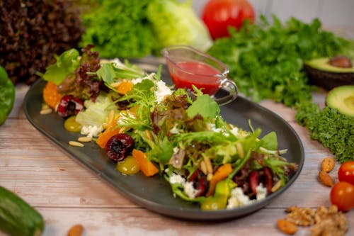 A plate of salad with vegetables and nuts on it