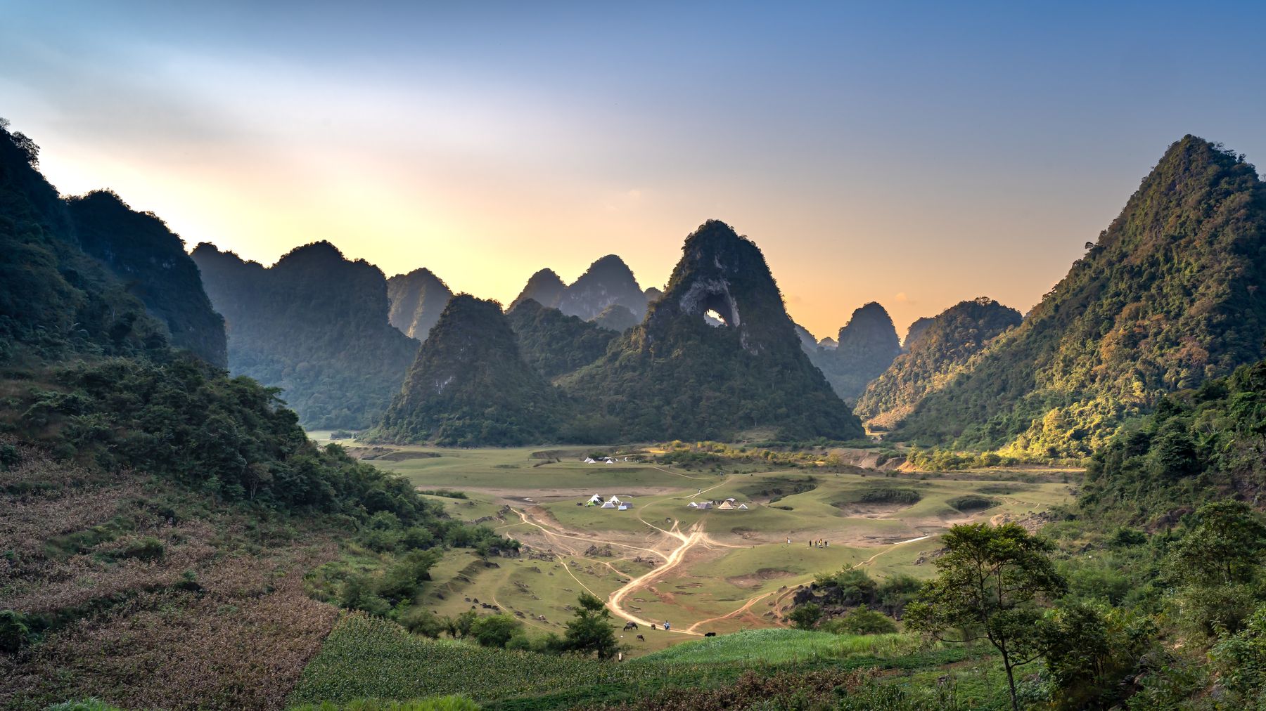 Khung cảnh ngoạn mục của những ngọn núi hùng vĩ và thung lũng xanh mướt lúc hoàng hôn.