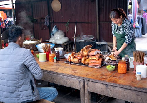 Woman Cooking Traditional Food on a Market 