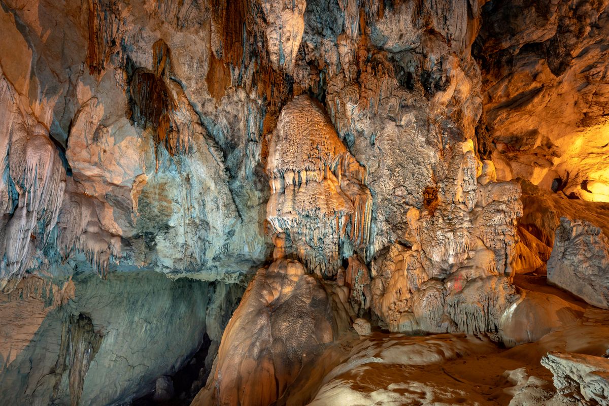 Ahşap masada dağılmış altın madeni taşları ve küçük madenci feneri