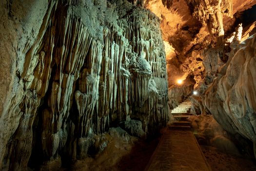 Explore the mesmerizing interior of a natural cave featuring impressive stalactites and stalagmites formations.