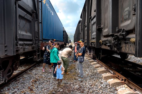 People between Cargo Trains