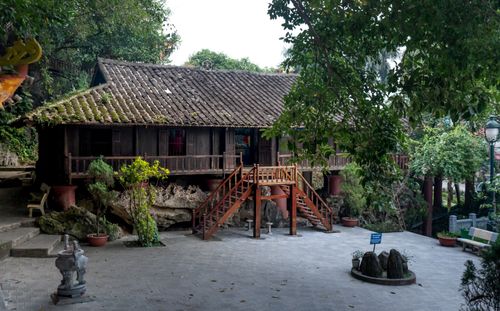 Free Rustic wooden house with stairs amidst lush greenery, serene outdoor scene. Stock Photo