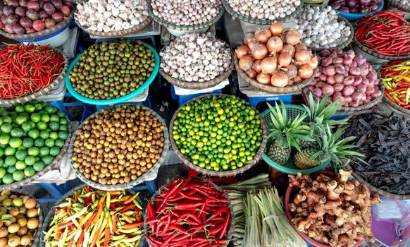Top-down view of vibrant fruits and vegetables displayed at an outdoor market.