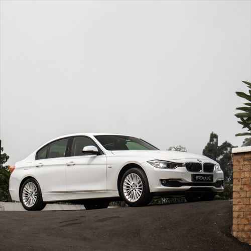 Free Elegant white sedan parked outdoors on a cloudy day. Stock Photo