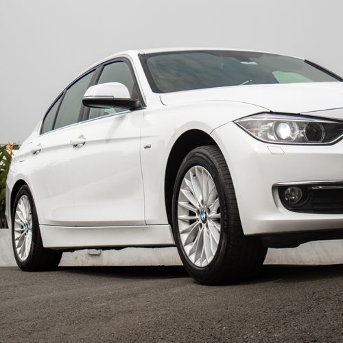 Free Elegant white luxury sedan parked at an angle on urban pavement, showcasing style and design. Stock Photo