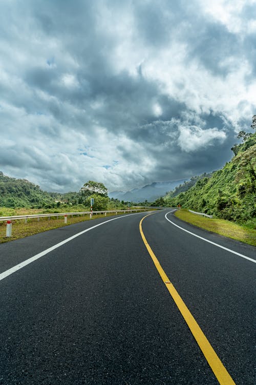 アスファルト道路, 垂直ショット, 曇り空の無料の写真素材