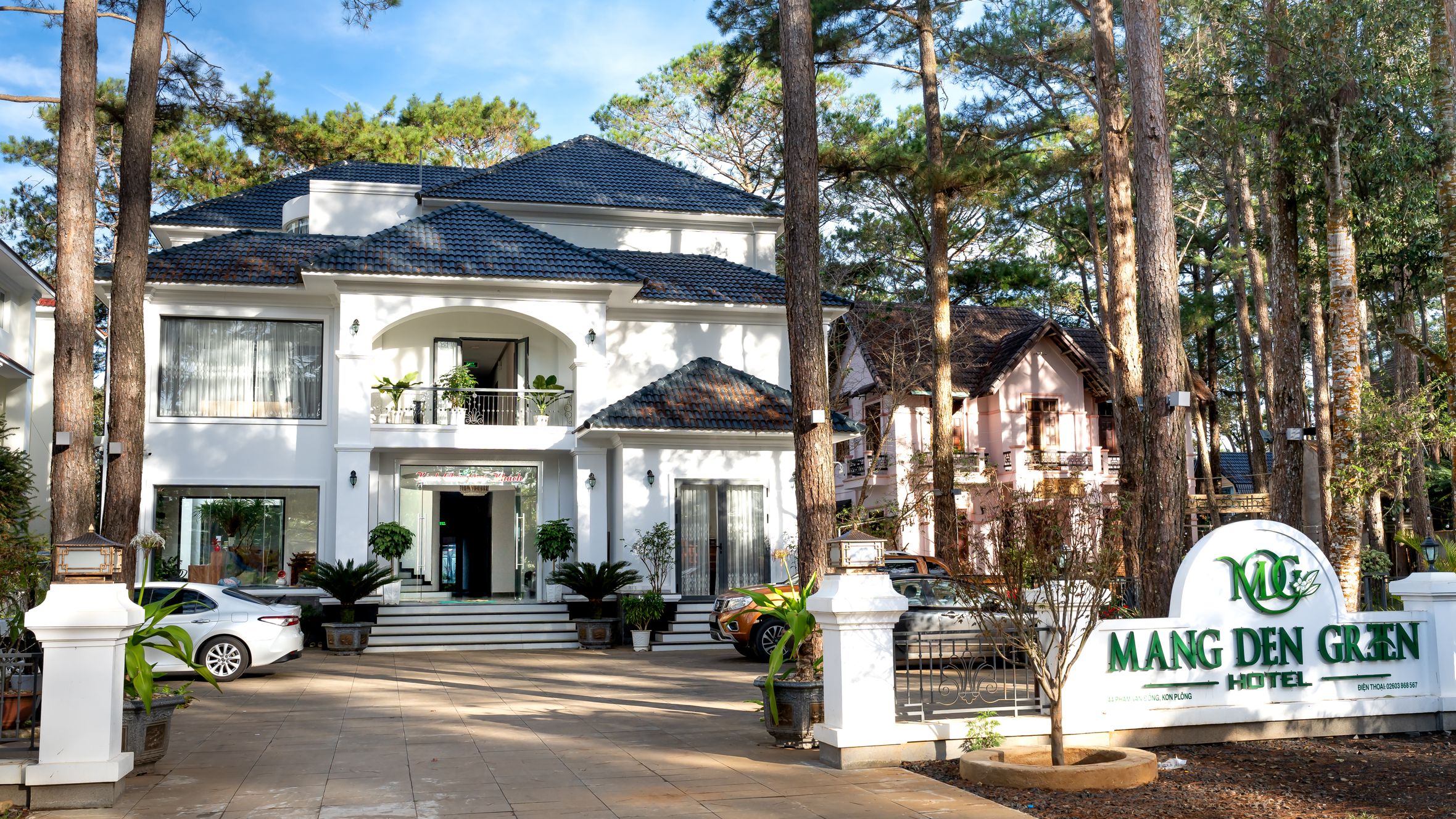 Beautiful entrance of Mang Den Green Hotel surrounded by serene forest. Ideal for luxury stays.