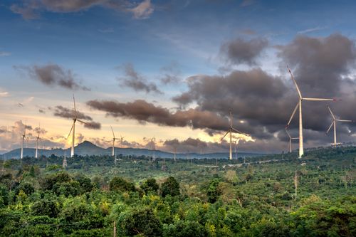 Free Explore the serene landscape view with wind turbines in a lush, countryside setting under a dramatic sky. Stock Photo
