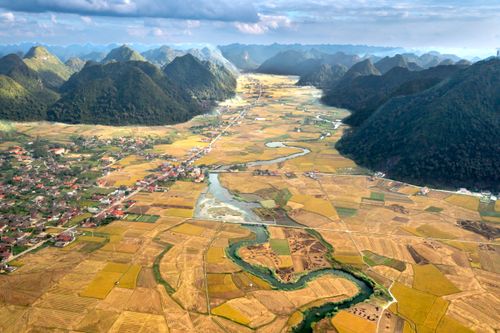Free Aerial shot of colorful fields and mountains creating a stunning rural landscape. Stock Photo