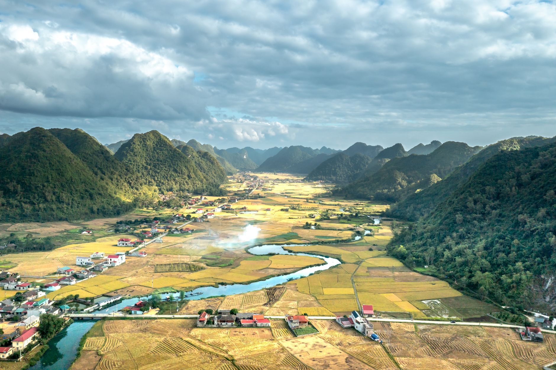 Beautiful aerial view of rural valley with mountains, villages, and river.