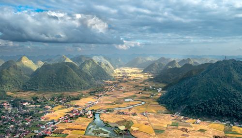 Free Stunning aerial view of lush valley and scattered villages surrounded by mountains. Stock Photo