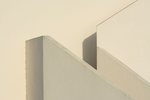Free A sunlit close-up of intersecting architectural walls with a minimalist design. Stock Photo