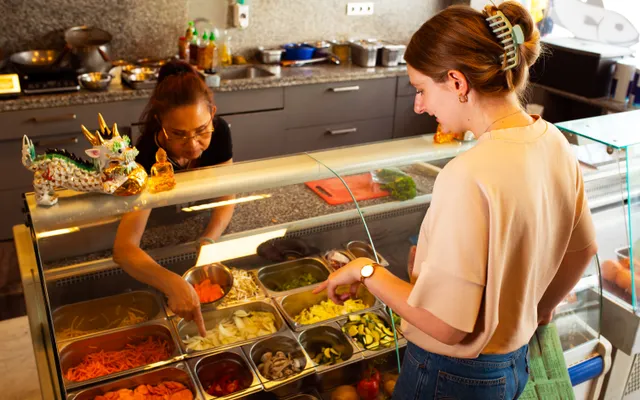 Une cliente choisit des plats au comptoir d’un restaurant
