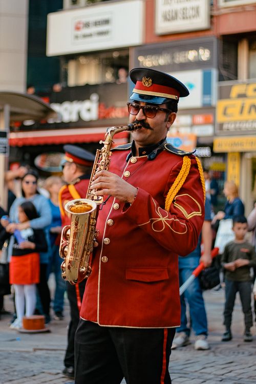 Free A saxophonist in a red uniform performs during a lively street parade in Denizli, Turkey. Stock Photo