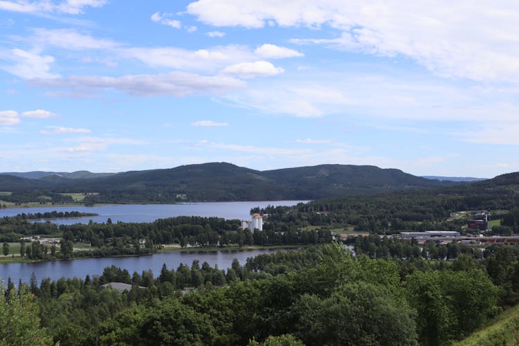 A View Of A Lake And Mountains From A Hill