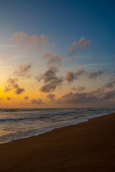 Mesmerizing sunset at an empty beach with gentle waves and colorful skies, perfect for relaxation.