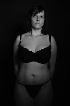 Artistic black and white photo of a woman in lingerie, capturing elegance and beauty.