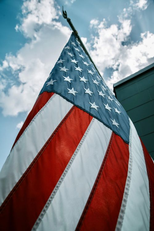 Free Close-up of USA flag with stars and stripes against a vibrant sky. Stock Photo