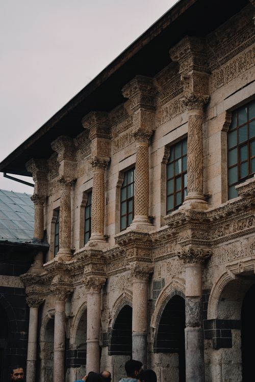 Free A stunning ancient building with intricately carved stone columns and arched windows. Stock Photo