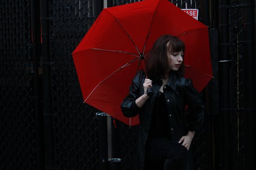 Caucasian woman in black leather jacket with red umbrella outdoors in Sanford, FL.