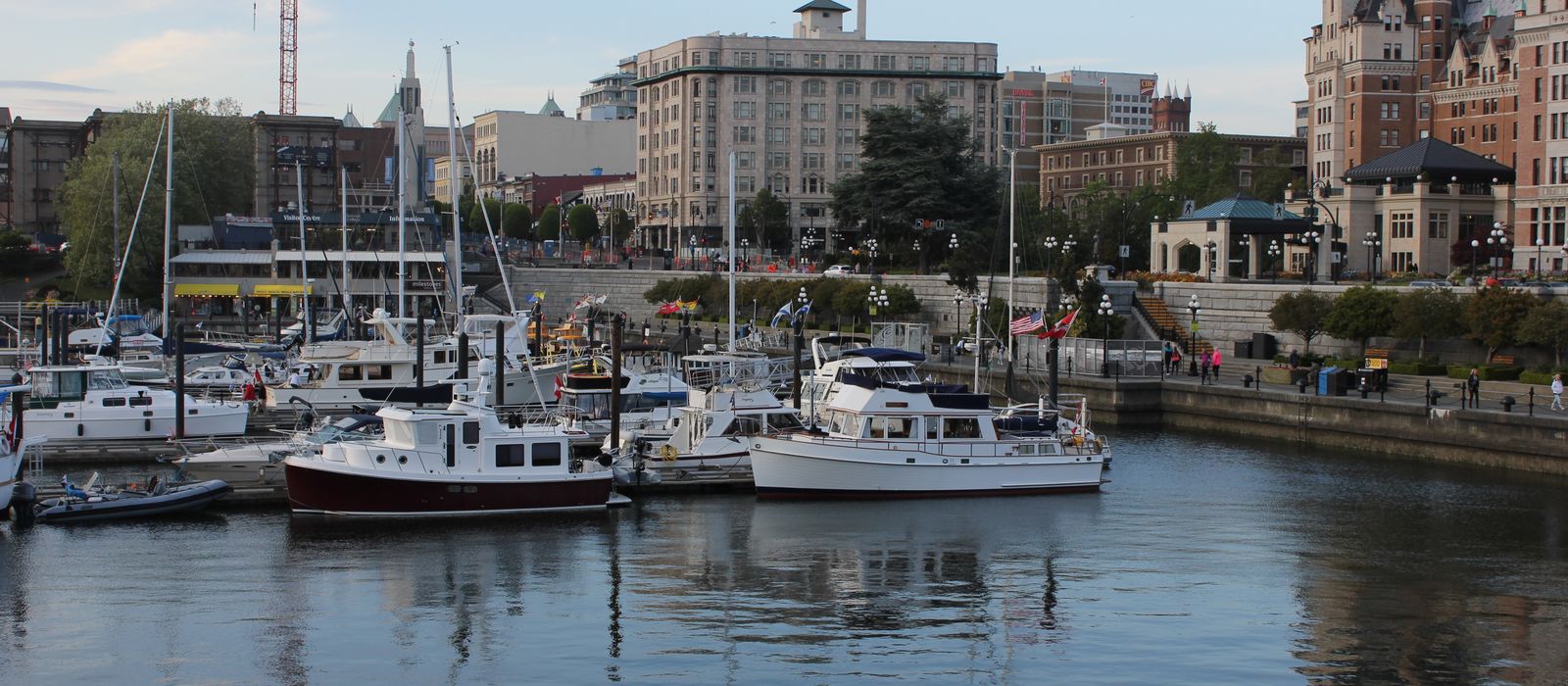Scenic view of Victoria's bustling harbor with moored yachts and historic architecture.
