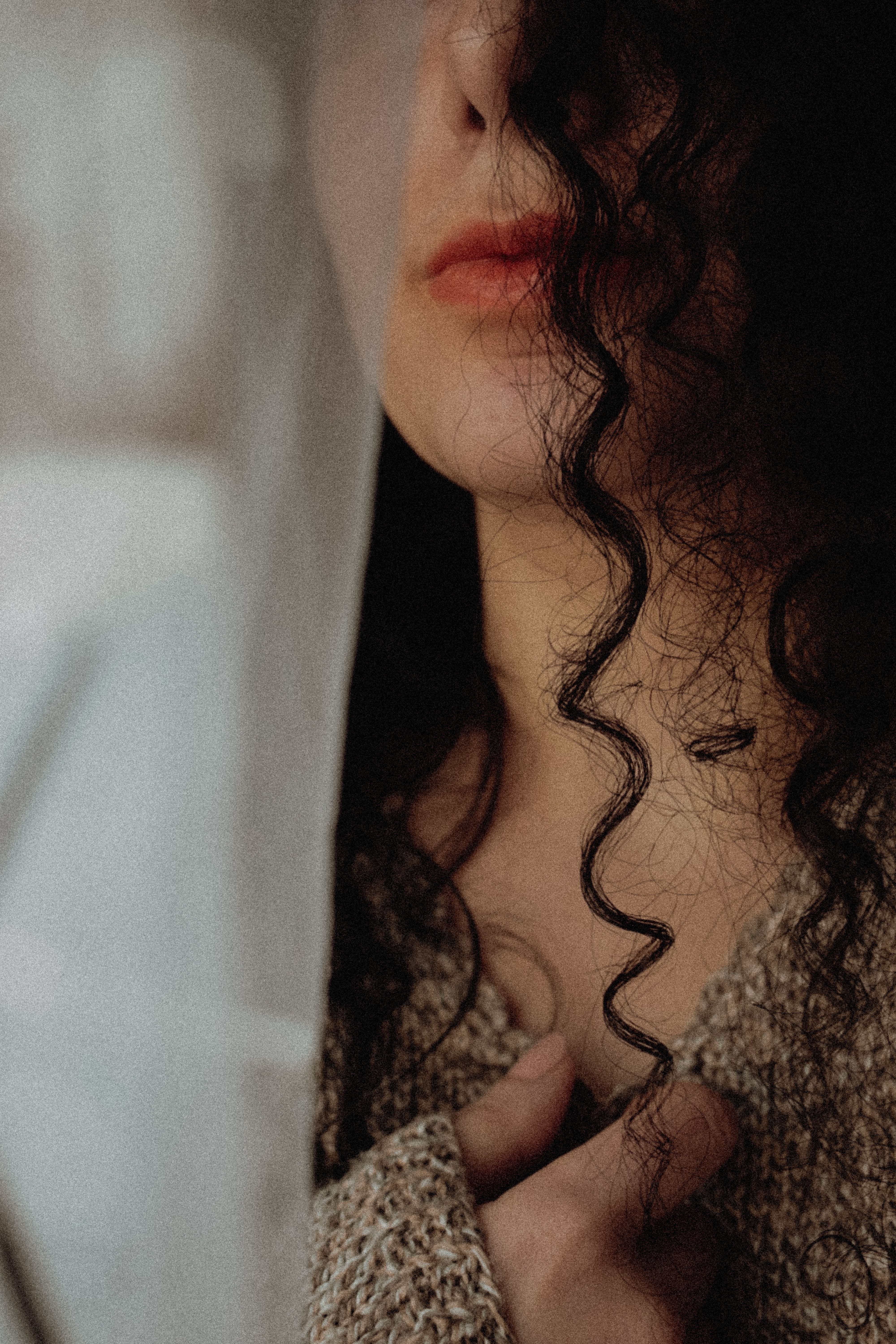 Subtle and mysterious portrait capturing the elegance of a woman with curly hair.