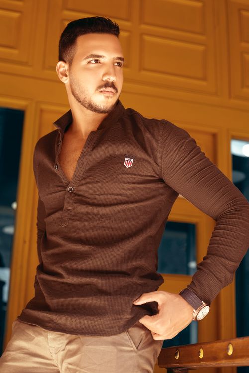 Free Fashionable man posing confidently indoors with stylish attire and accessories. Stock Photo