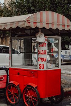 A classic red food cart on the street offers simit, şalgam, ayran, and water.