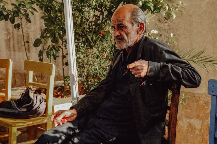 Elderly Man Sitting On A Chair