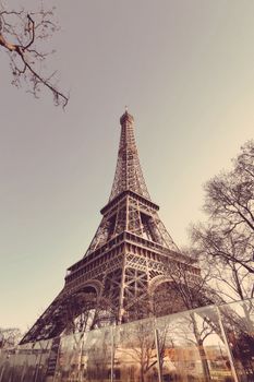 Classic low angle shot of the Eiffel Tower in Paris, a renowned tourist attraction and historic landmark.
