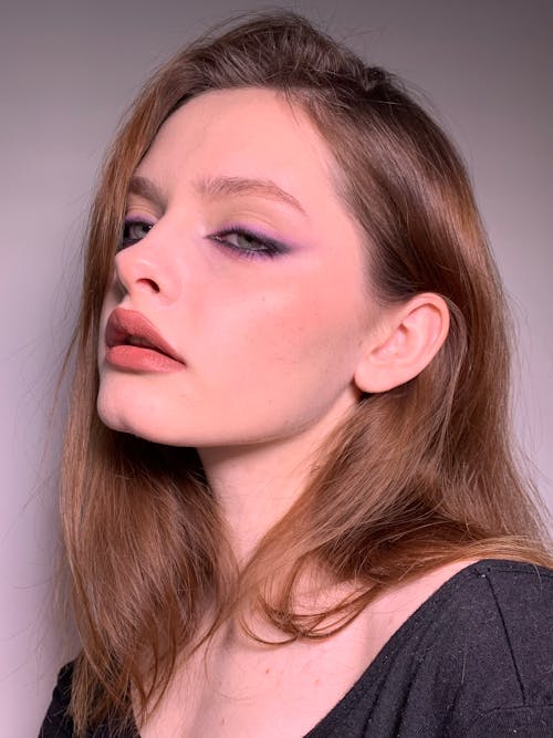 Photo of a Young Woman with Purple Eye Makeup 