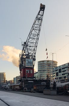 A striking view of a harbor crane amidst modern buildings in Hamburg's port.