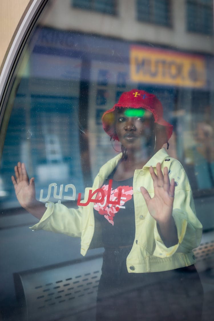 Woman Wearing Bucket Hat Standing Behind Glass Window