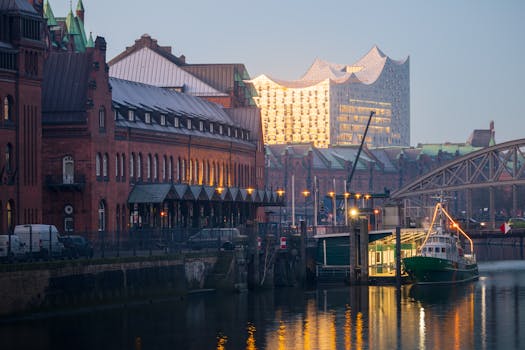 View of Hamburg's Speicherstadt and Elbphilharmonie reflecting at dusk, showcasing architectural beauty.