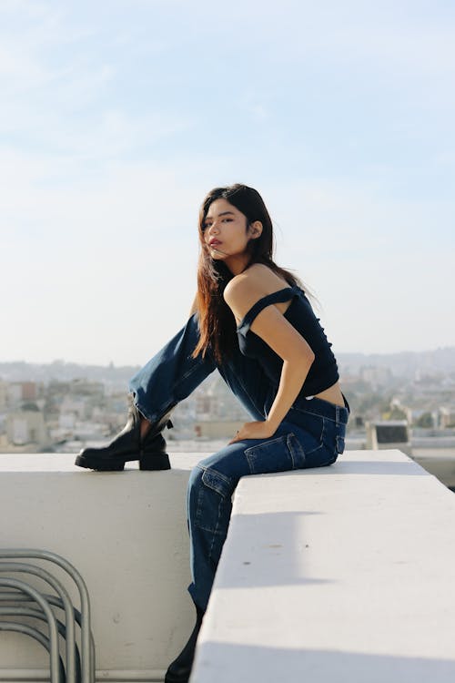 Young Fashionable Woman Sitting on a Rooftop 