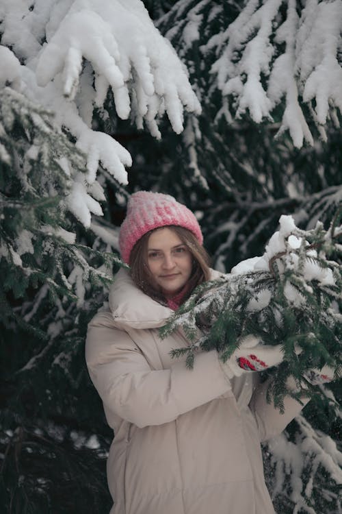 Woman in White Winter Jacket Standing beside Snow Covered Trees