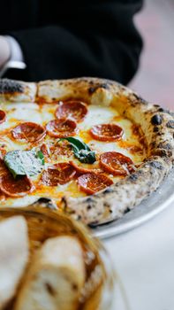 Close-up of a freshly baked pepperoni pizza with basil and cheese.