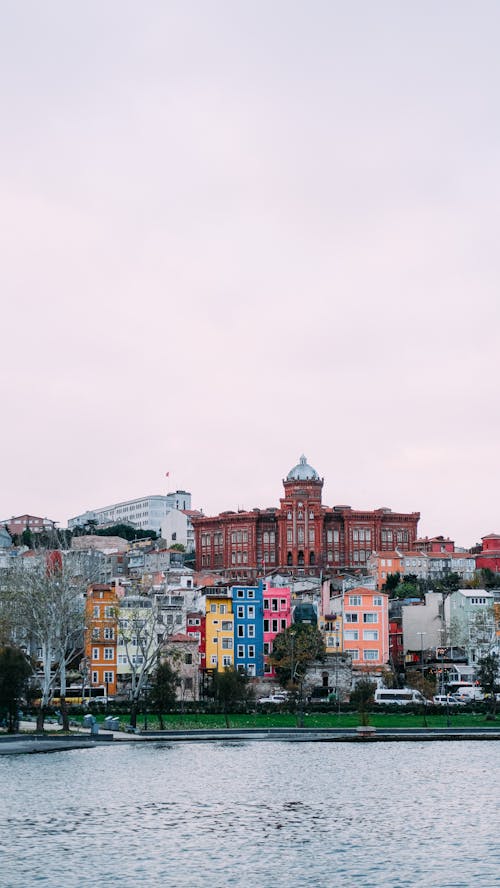 Phanar Greek Orthodox College above Colorful Buildings by Riverbank in Istanbul, Turkey